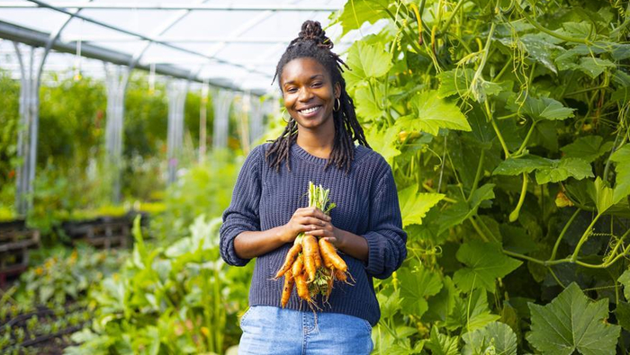 Woman holding vegetables on a community farm 