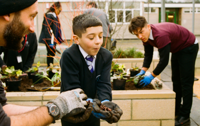 School boy growing food in local community